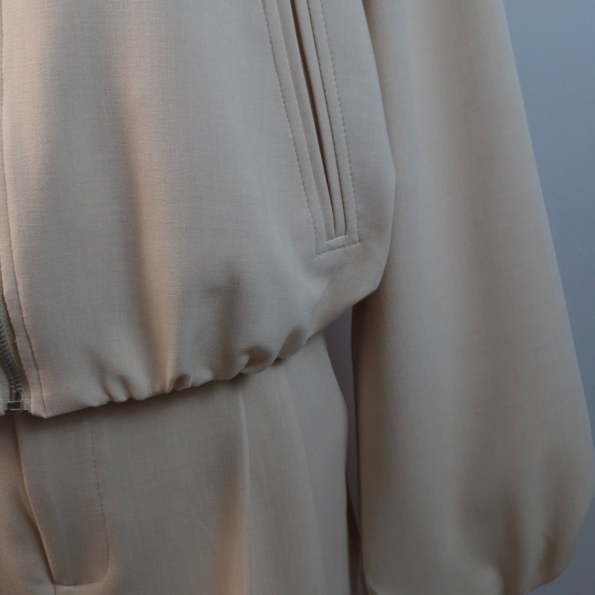 La Vie Continue beige polyester blend bomber jacket and high-waisted trousers set. Jacket features zip closure and blouson effect.