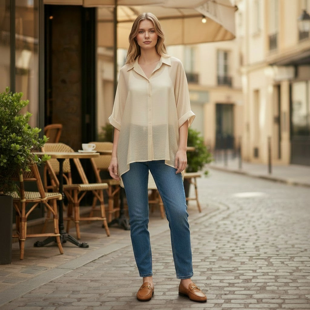 La Vie Continue beige oversized fluid shirt made of lyocell and polyester with rolled-up sleeves, worn by a model with blue jeans.
