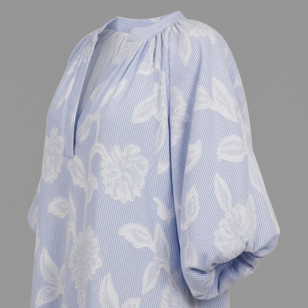 La Vie Continue light blue floral cotton dress with V-neck, puffed sleeves, and side pockets. Perfect for summer.