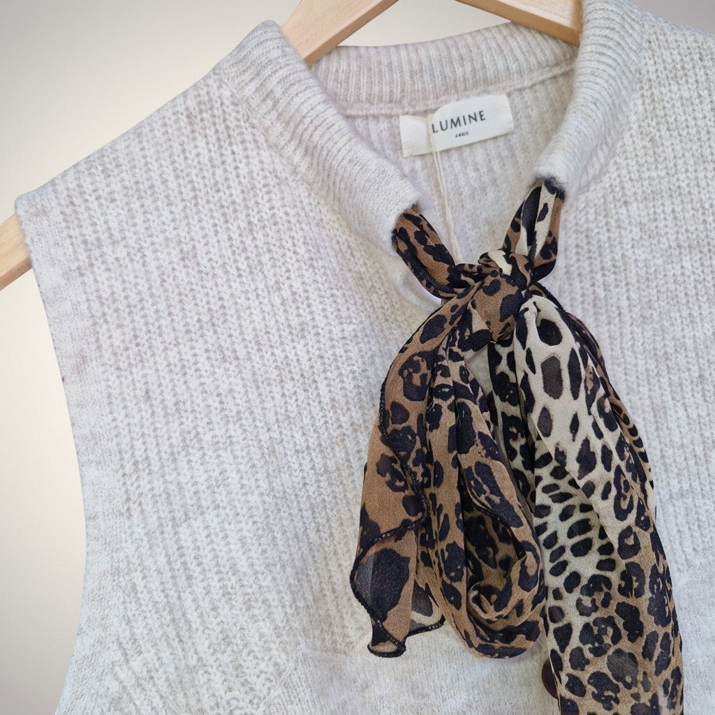 La Vie Continue cream knit sleeveless vest with a leopard print scarf tied at the neck. Autumn/Winter 2025/2026 collection.