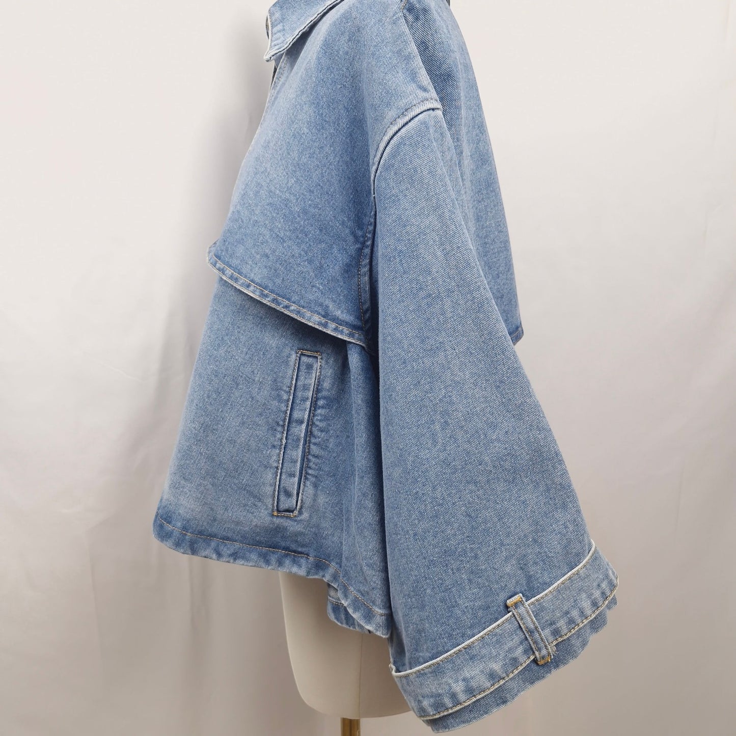 La Vie Continue light wash denim cape jacket with relaxed fit and button-front closure.