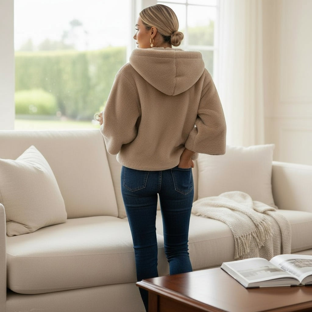 La Vie Continue ecru fleece hooded jacket with wide sleeves and front pockets, worn by a woman in jeans.