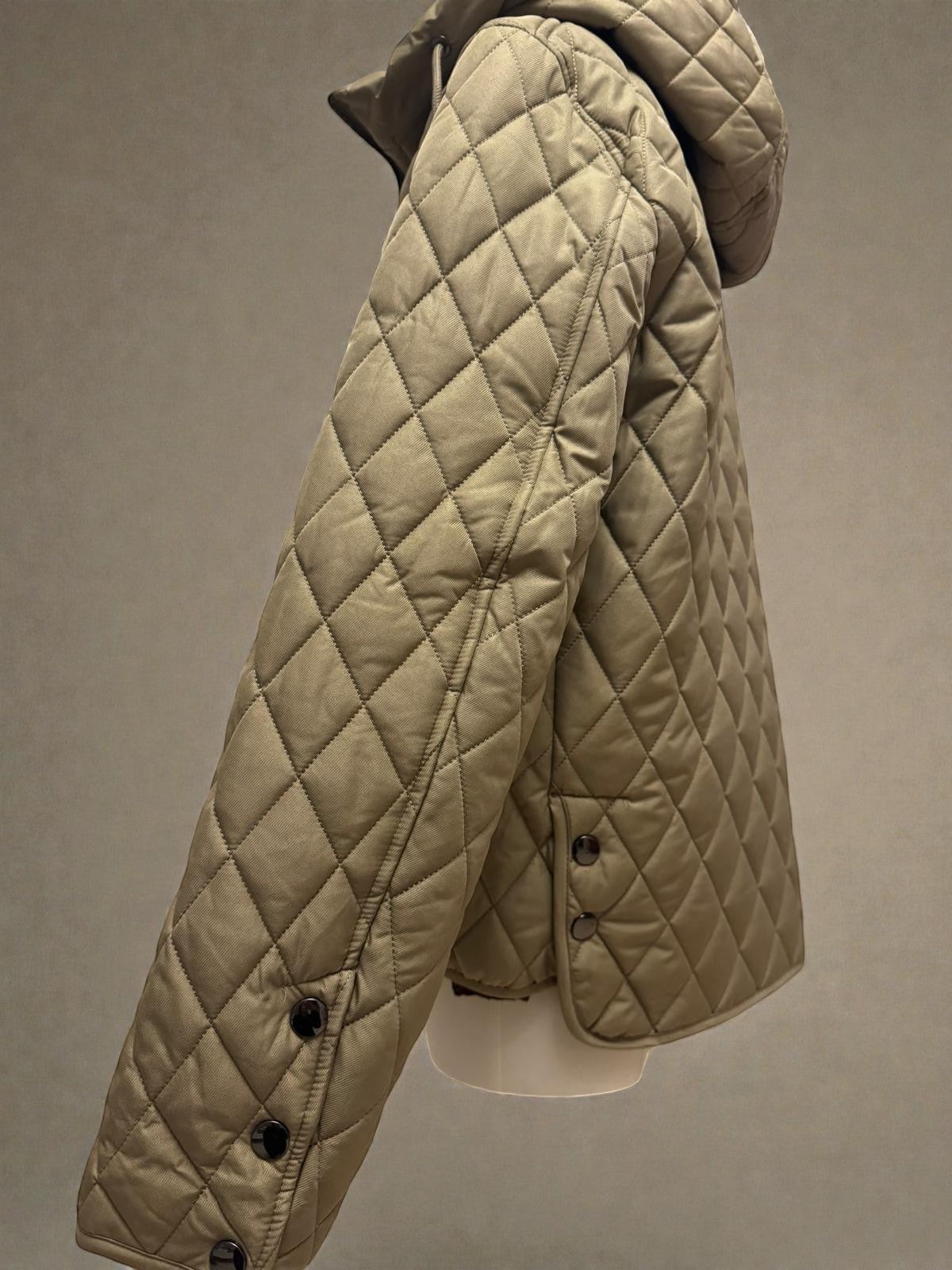 La Vie Continue khaki quilted jacket with diamond pattern and hood. Lightweight polyester, ideal for transitional weather.