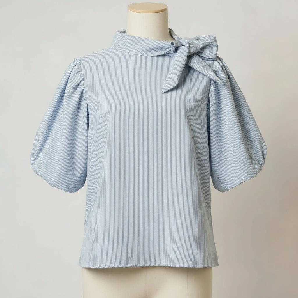 La Vie Continue light blue striped cotton-blend blouse with puffed short sleeves and a tie-neck detail.