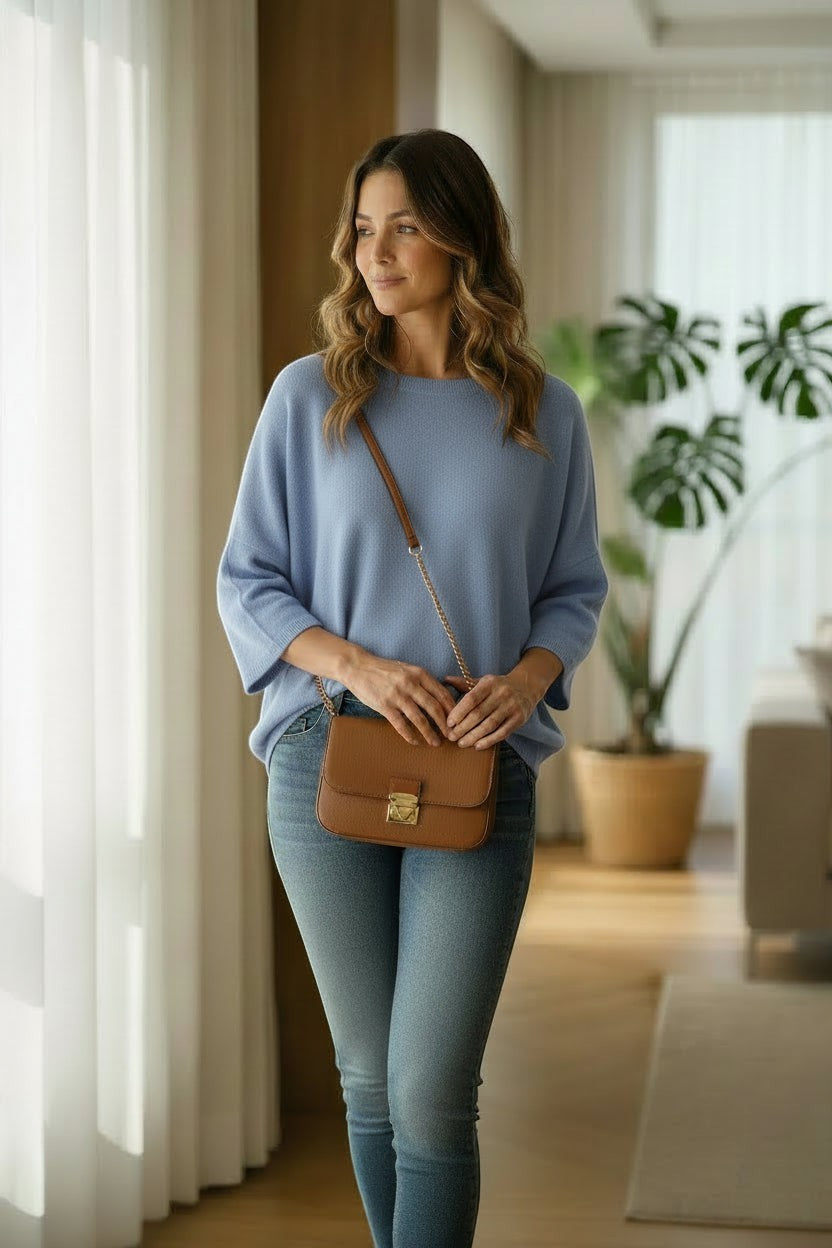 La Vie Continue light blue relaxed fit sweater with wide sleeves and round neck, worn by a woman with jeans.