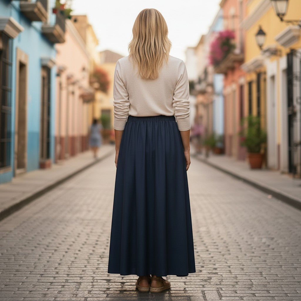 La Vie Continue navy blue viscose and linen blend maxi skirt with elastic waist, worn by a woman standing on a cobblestone street.